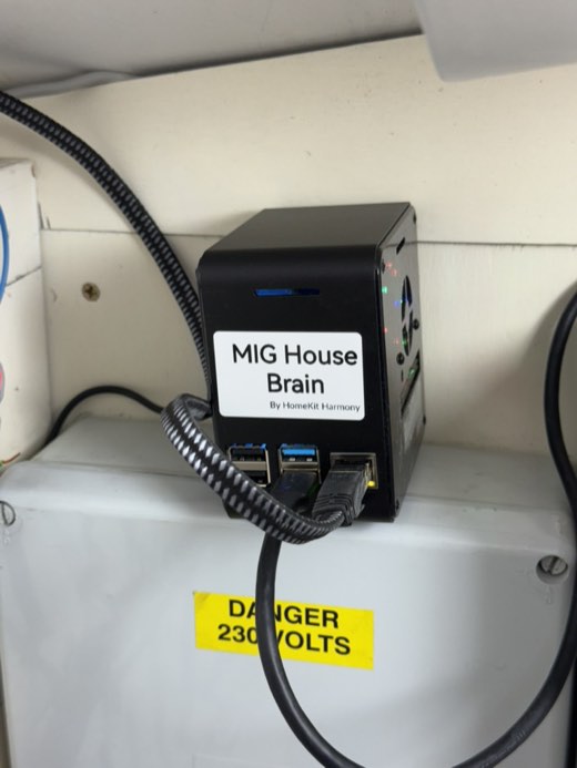 A Raspberry Pi in a black case mounted above the consumer unit, labelled as the house controller